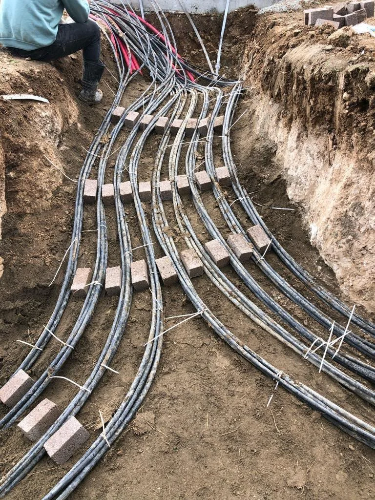 Yayında kabloların yerleştirildiği ve düzenlendiği inşaat sahası, yer kazılmış ve kablolar briketler ile düzenlenmiş.