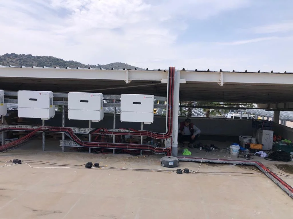 Çatı üzerinde elektrik ve iletişim altyapısı kuruluyor, birkaç kişi çalışıyor.