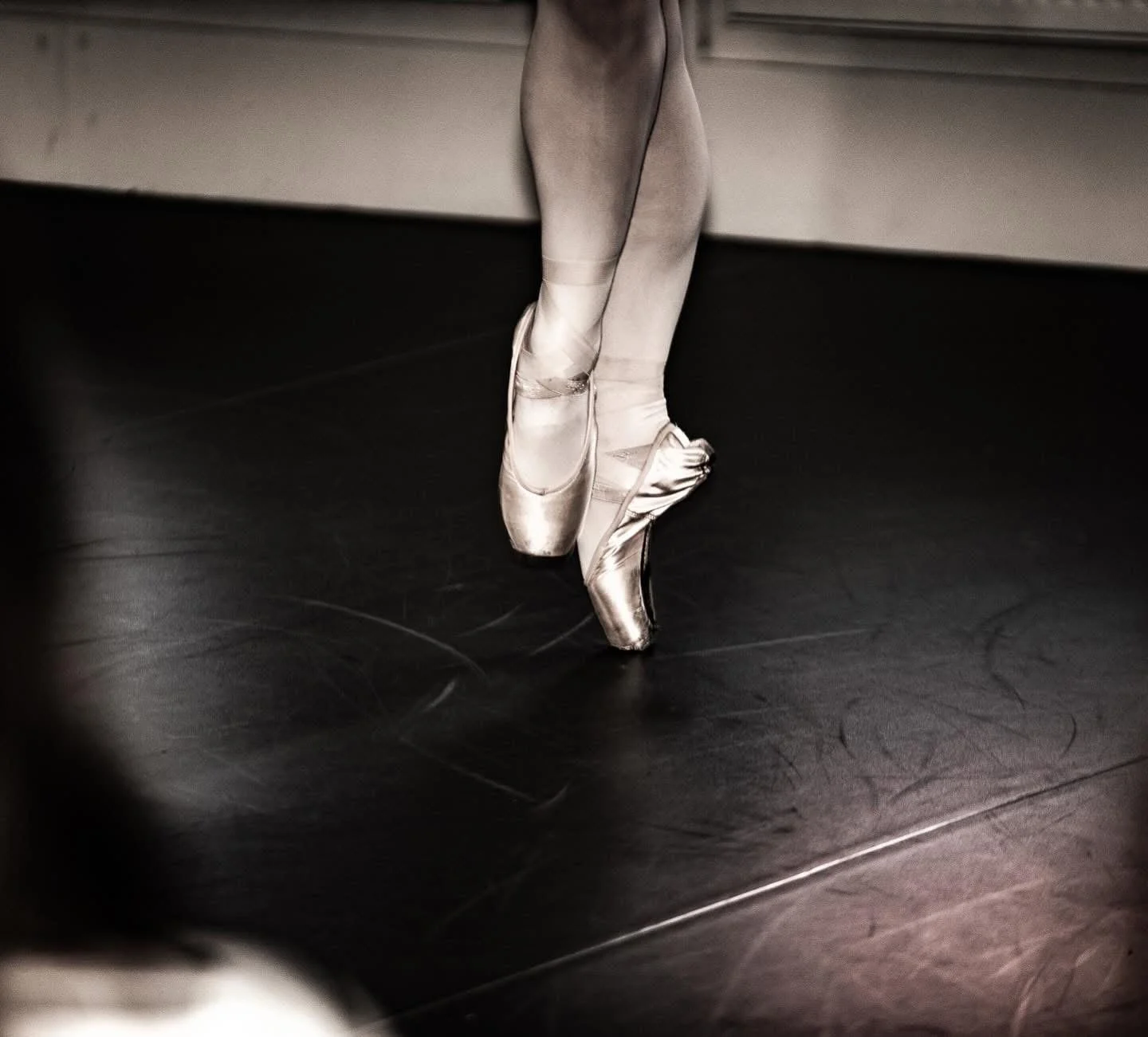 Ballerinas stående på tåspetsar i en dansstudio.