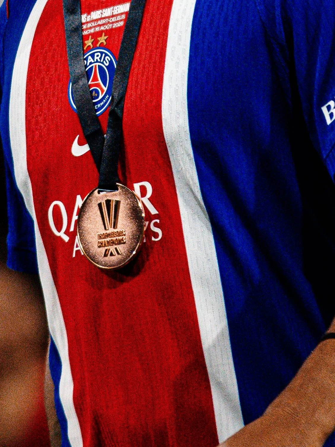 Maillot de football de Paris Saint-Germain avec médaille à côté.