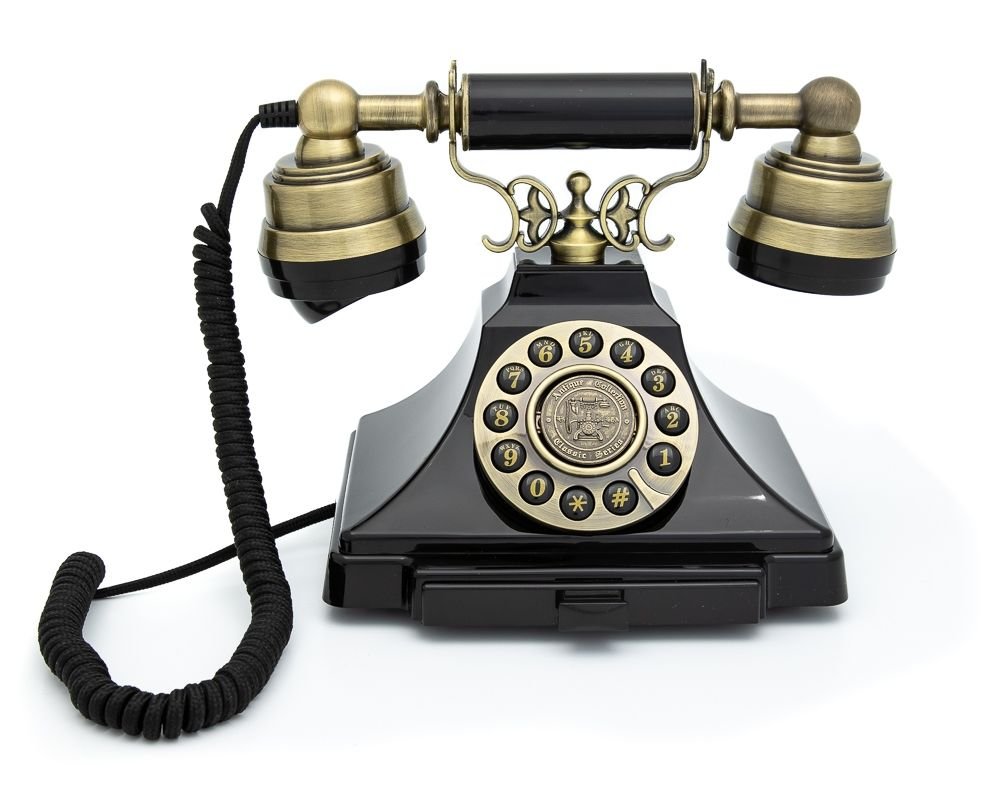 Vintage rotary dial telephone with brass accents and a coiled cord.