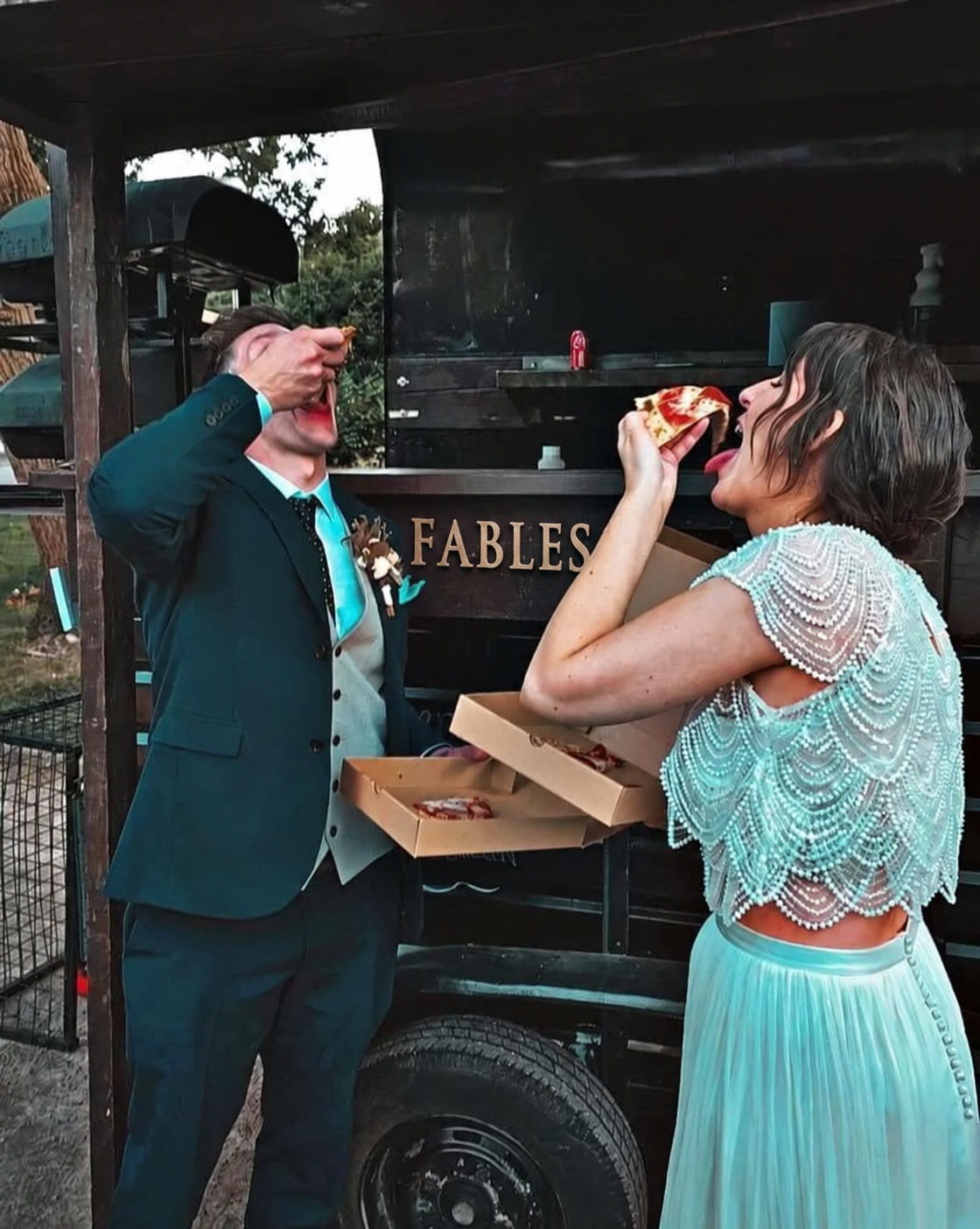 Guests enjoying pizza beside a Fables vintage horsebox at an outdoor event