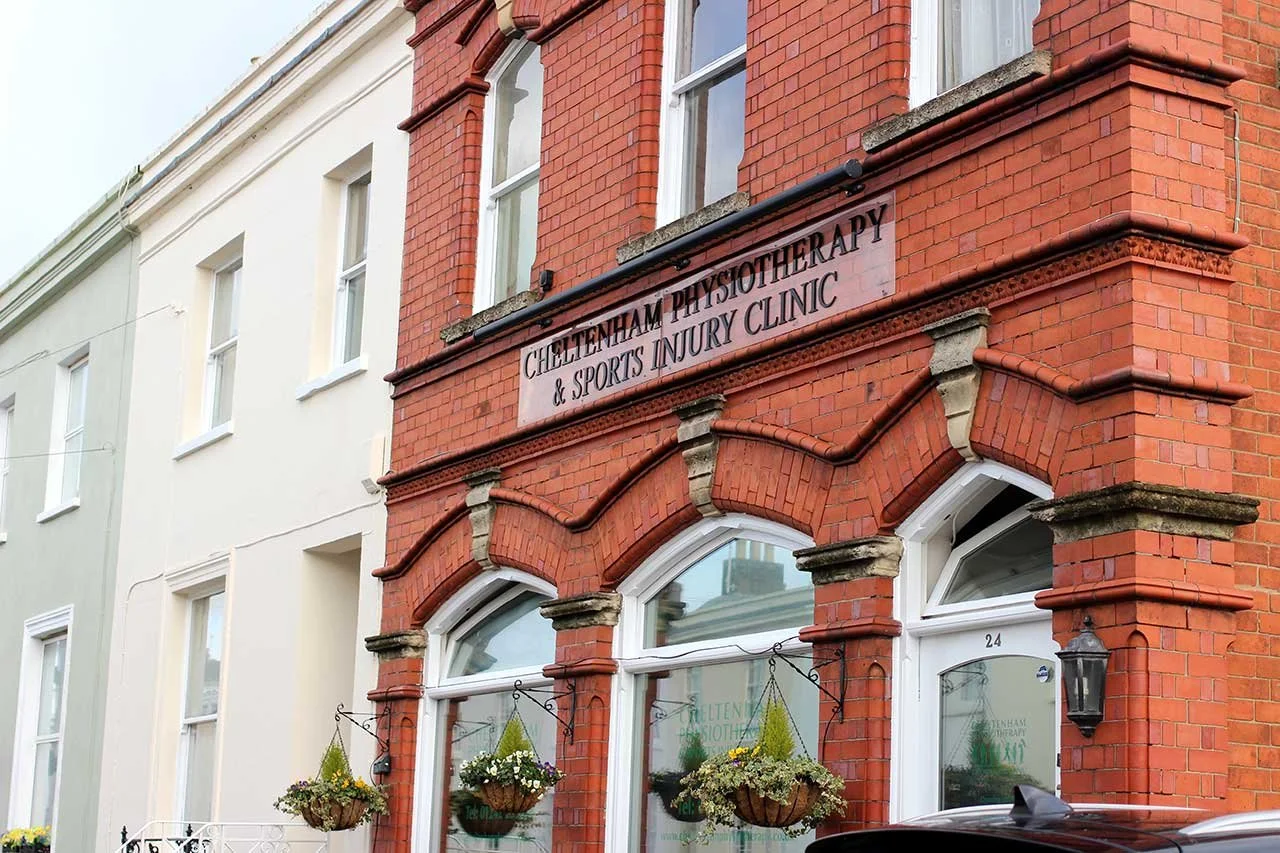 The front of a brick building with a sign that reads 'Cheltenham Physiotherapy & Sports Injury Clinic'.