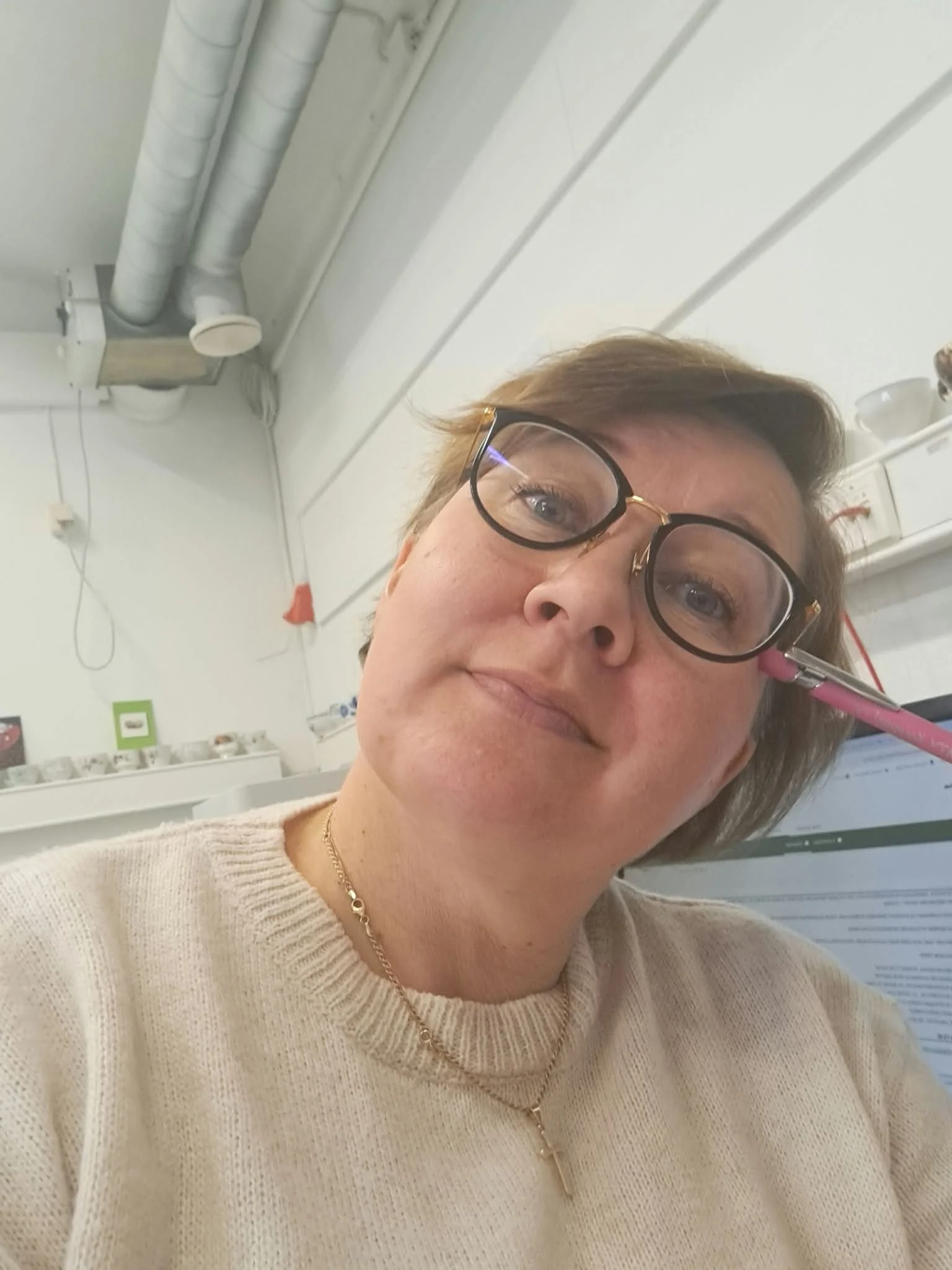 Nainen käyttää silmälaseja ja suorittaa injektion kasvolle.