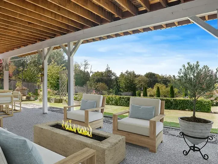 Outdoor patio with wooden furniture, a rectangular fire feature, a potted plant, and a view of a garden and trees under a blue sky