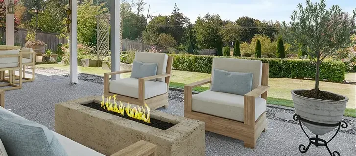Outdoor patio area with modern chairs, a rectangular fire feature, and a potted tree, overlooking a backyard with grass and trees.