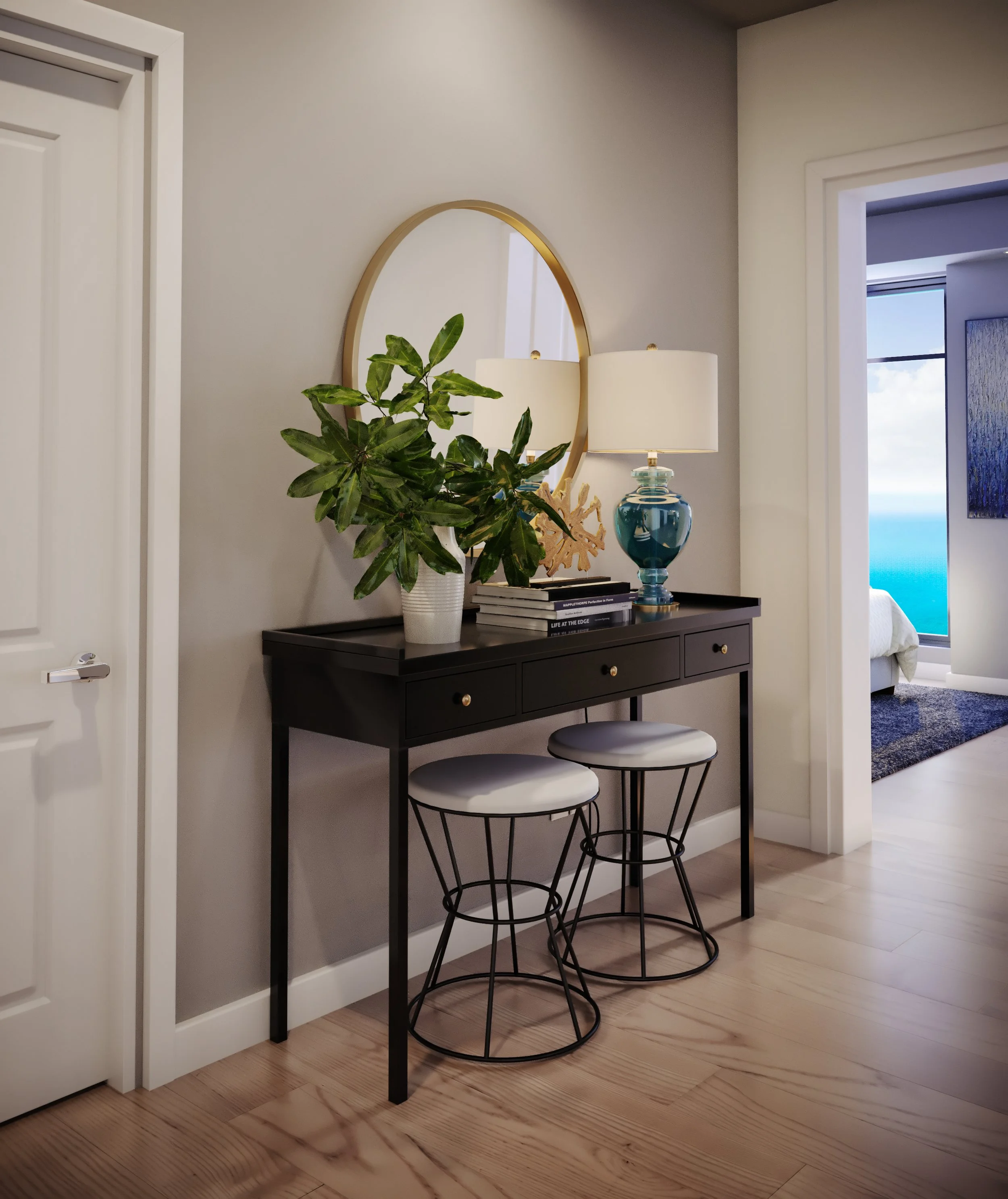 A corner of a room with a black console table against a light gray wall. On the table, there's a large green potted plant, a blue glass table lamp with a white shade, and a stack of books. Above the table, a round mirror with a gold frame hangs on th