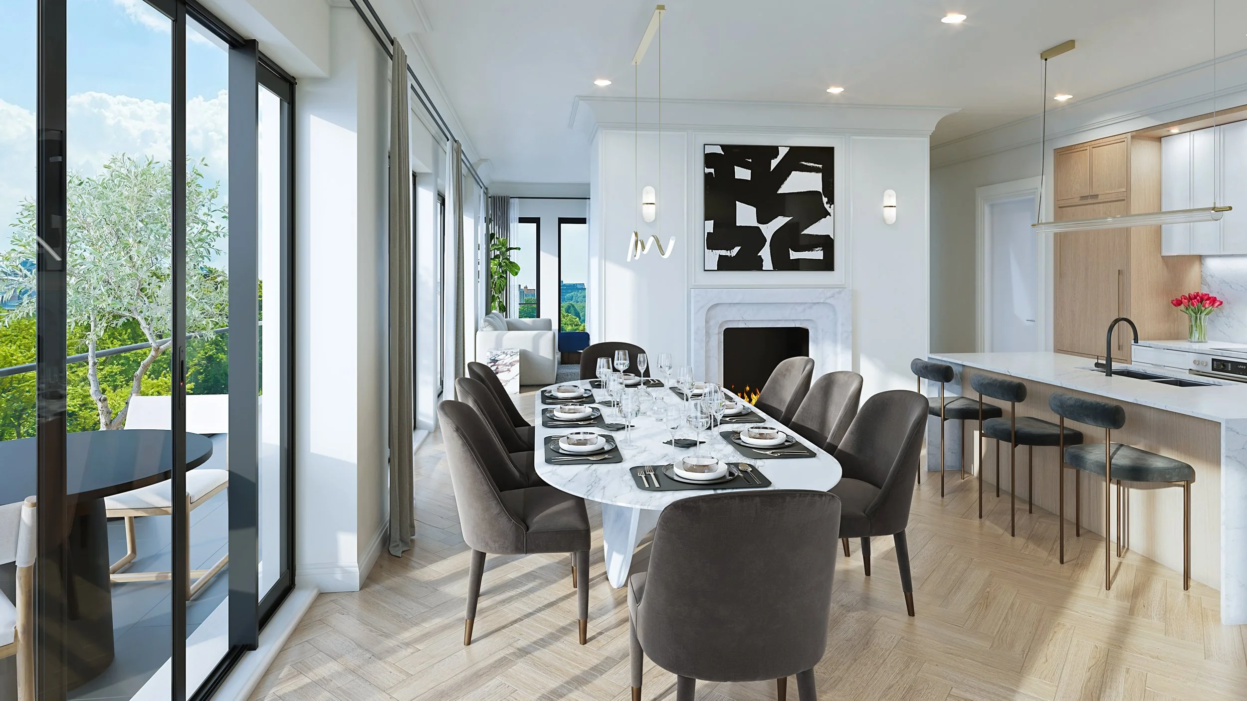 Modern living room with large windows showing outdoor greenery, a dining table set with white plates and glasses, a fireplace with black artwork, and a kitchen island with bar stools.