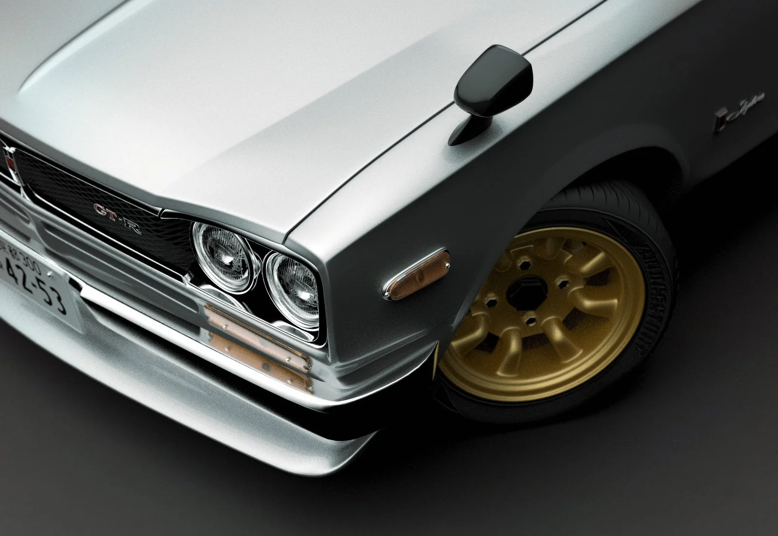 Close-up of front part of a classic silver and black Nissan GT-R sports car with gold wheels.