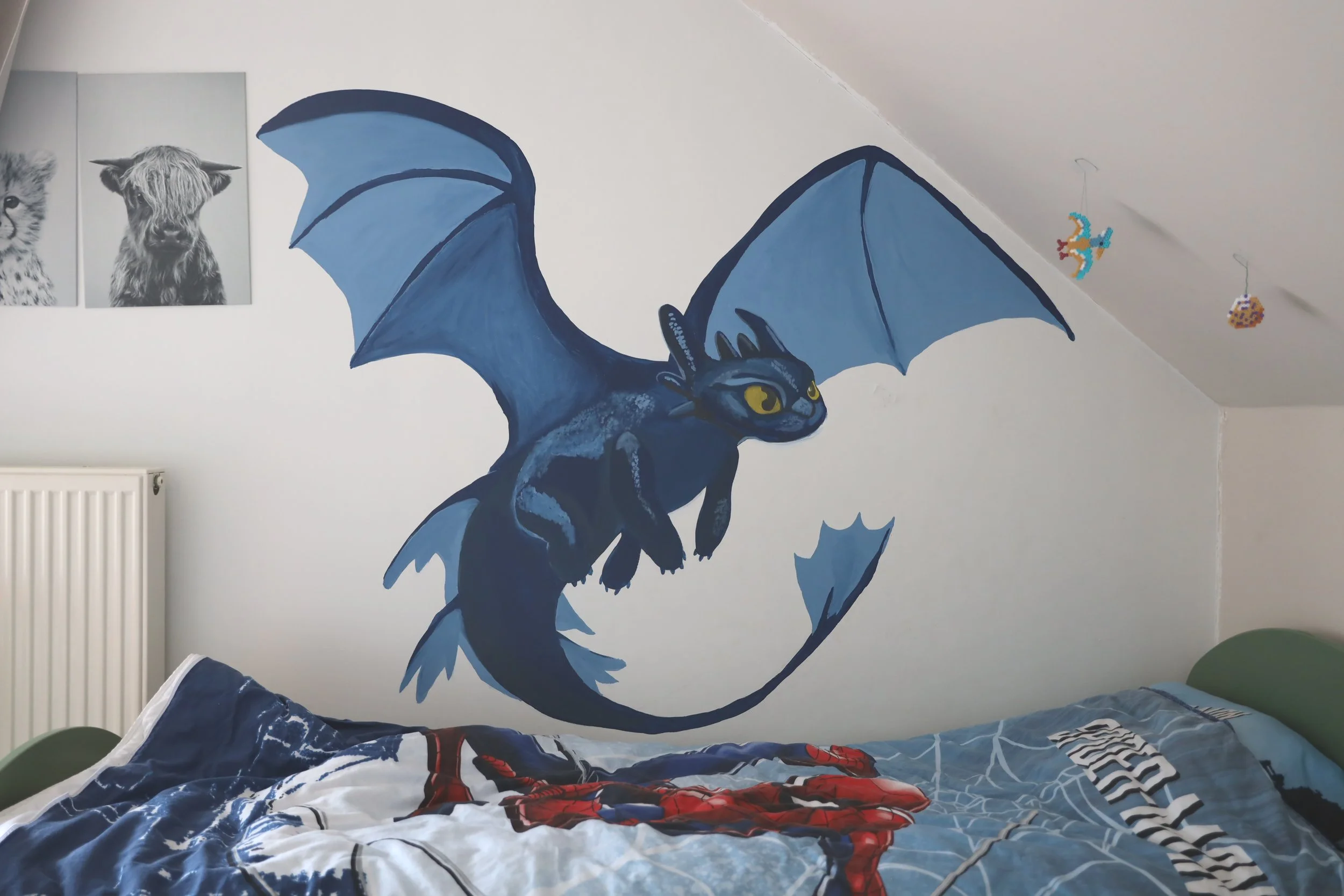 A wall decorated with a blue and black dragon mural, with black wings, yellow eyes, and a long tail.