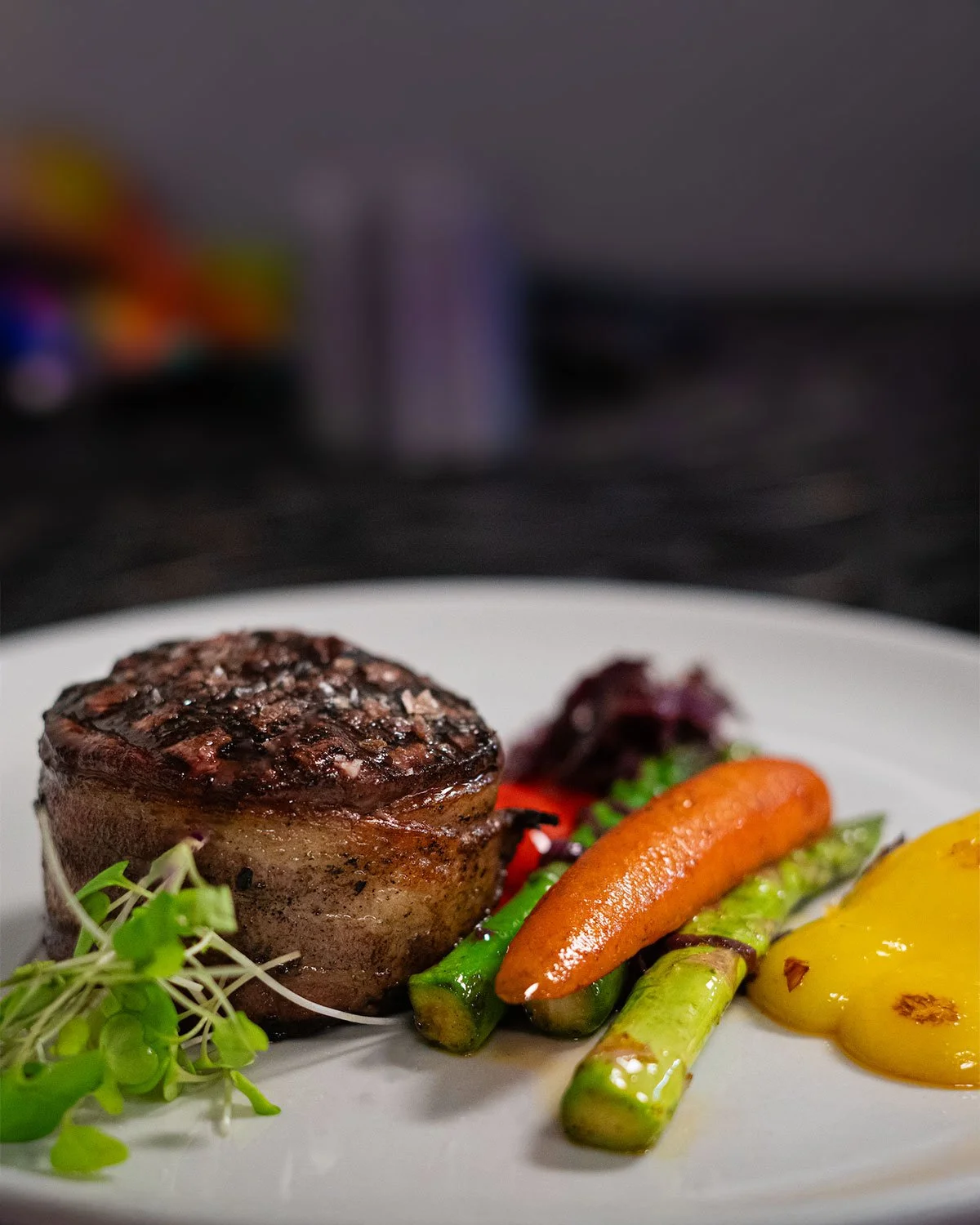 A plate with a steak and accompaniments at Conversate Steak & Seafood in Hamilton.