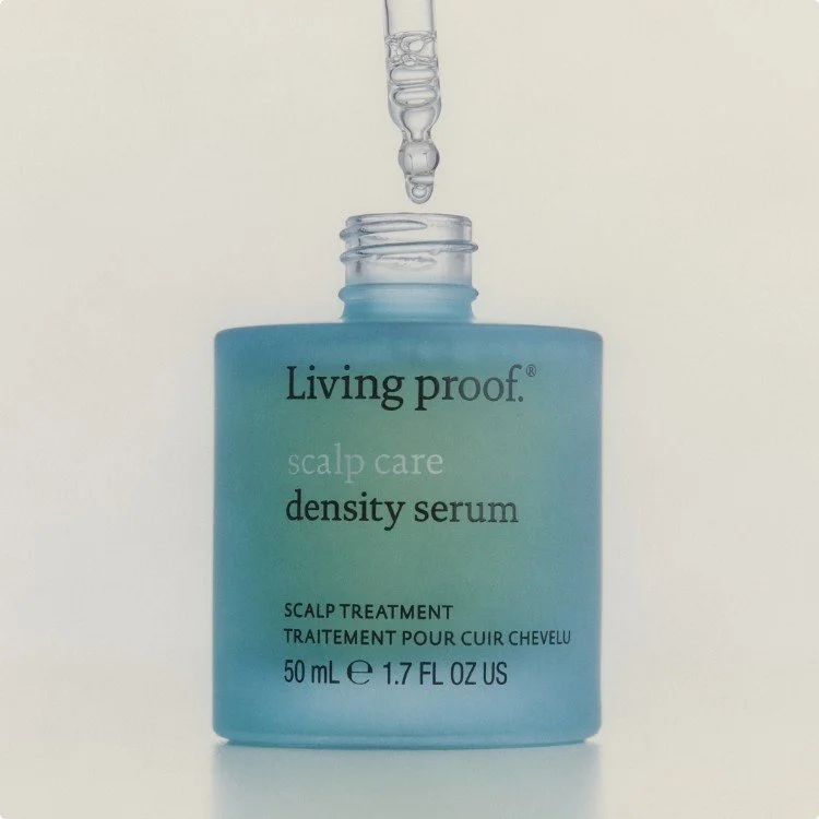 A bottle of Living Proof scalp care density serum with a dropper above it. The bottle is blue and the label includes product details in English and French.