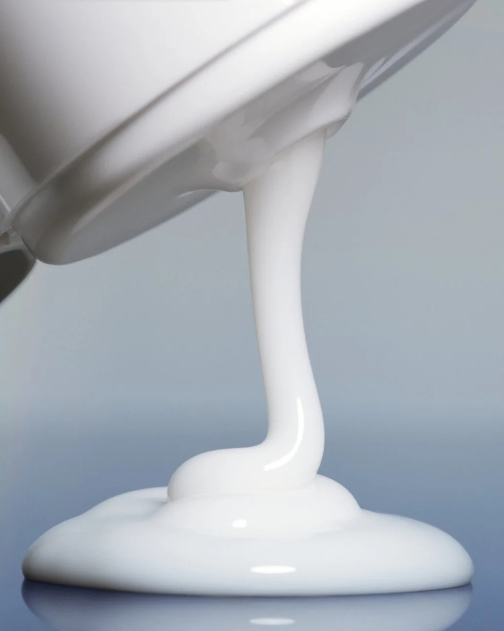 Cream being poured from a container onto a surface.