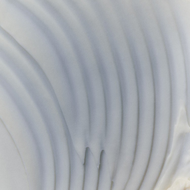 Close-up of a white spiral radiator or vent with curved lines.
