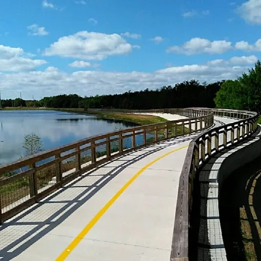 Curved walking and biking trail beside the water at Shingle Creek Regional Park.
