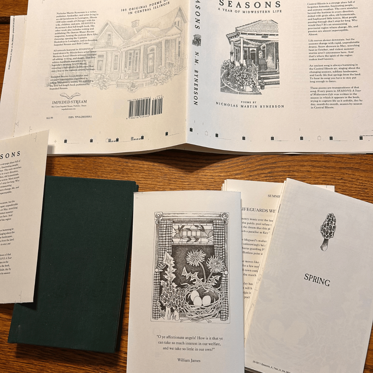 Open book titled 'Seasons: A Year of Midwestern Life' with poem illustrations and other papers on a wooden table.