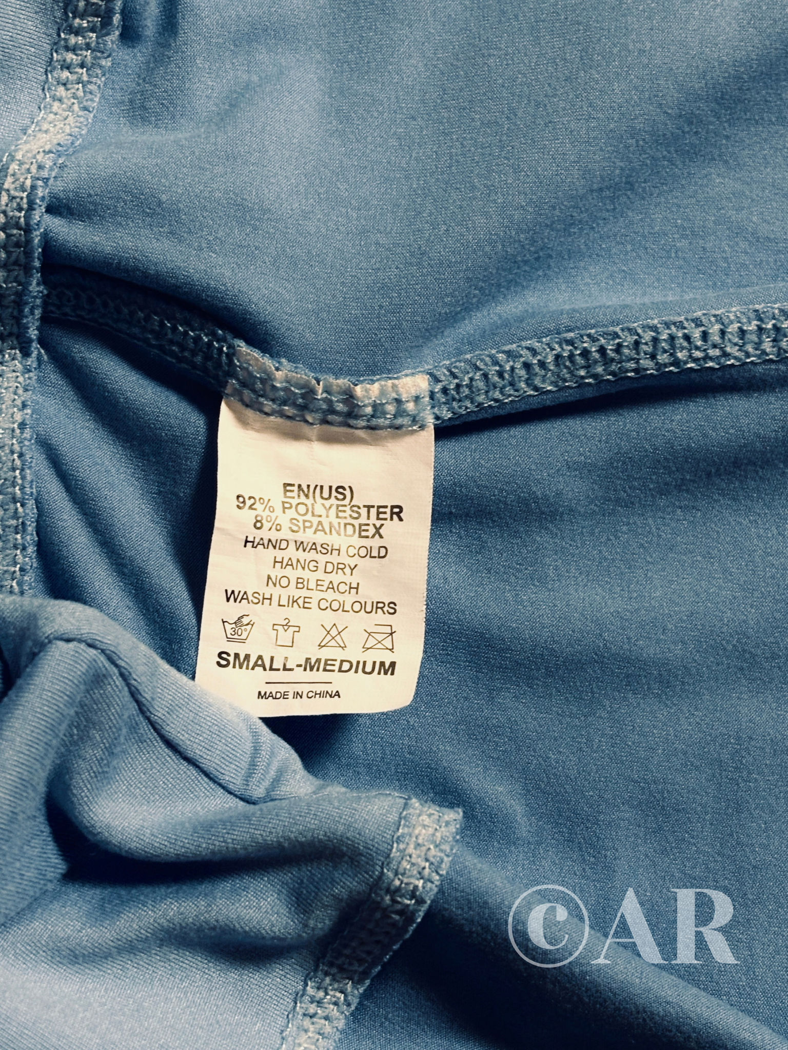A clothing tag showing a fabric blend of 92% polyester and 8% spandex.