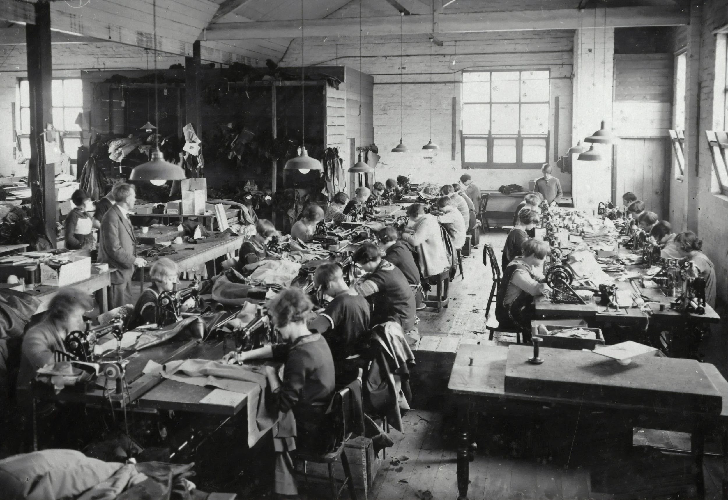 Black-and-white photograph of workers at rows of sewing machines inside Simpson’s Gloves factory, circa 1932.