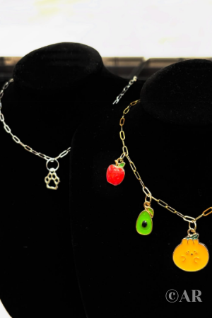 Two charm necklaces each on neck mannequins