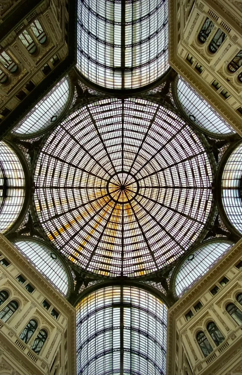 Cúpula de hierro y vidrio

Galleria Umberto I, Nápoles, Italia

La gran cubierta acristalada se apoya sobre una estructura metálica que organiza el espacio mediante una composición radial y simétrica. El contraste entre la ligereza de la cúpula y la 