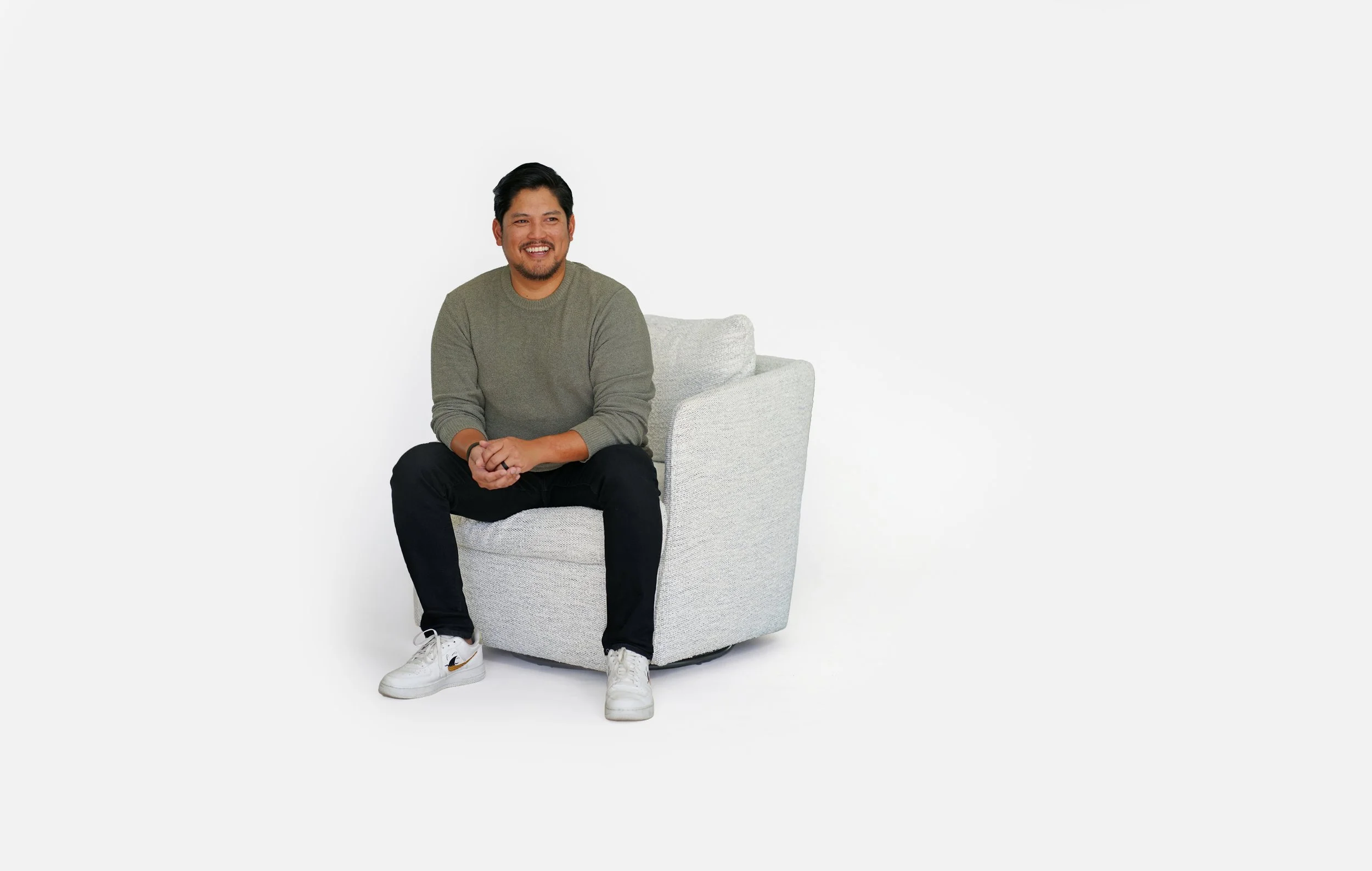 Paul Ringon sitting in a white chair, smiling