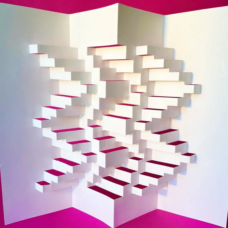 White three-dimensional wall art with geometric, staggered rectangular blocks creating a textured pattern, set against pink and white background.