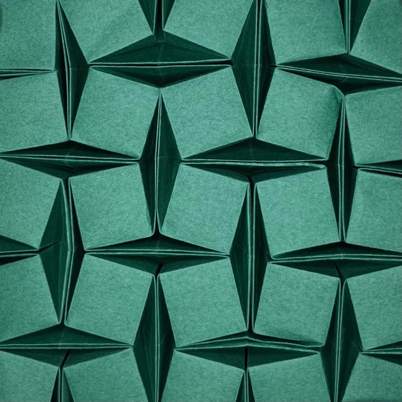 Close-up of teal origami paper cubes arranged in a geometric pattern.