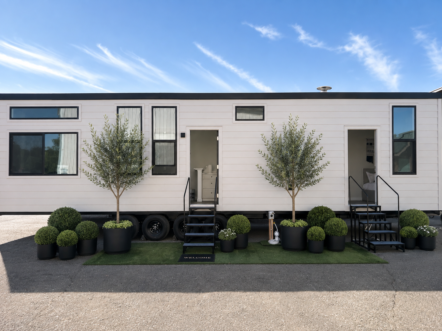 Forever 40′ 2B tiny home on wheels featuring fiber cement lap siding, a standing seam metal roof, and two exterior entry doors.