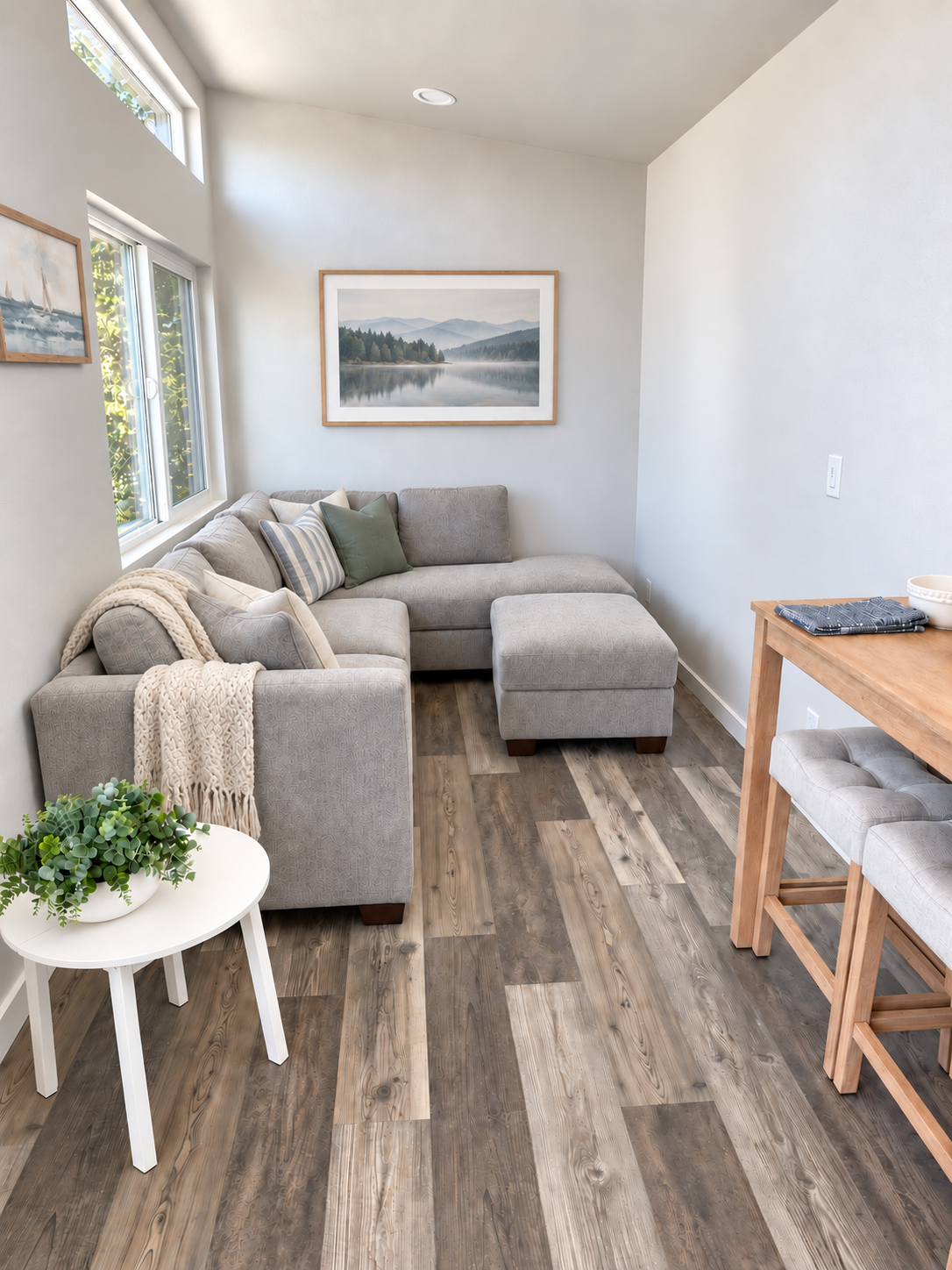 Forever 40-foot 2B living area with a light gray sectional sofa, large windows, and framed wall art.