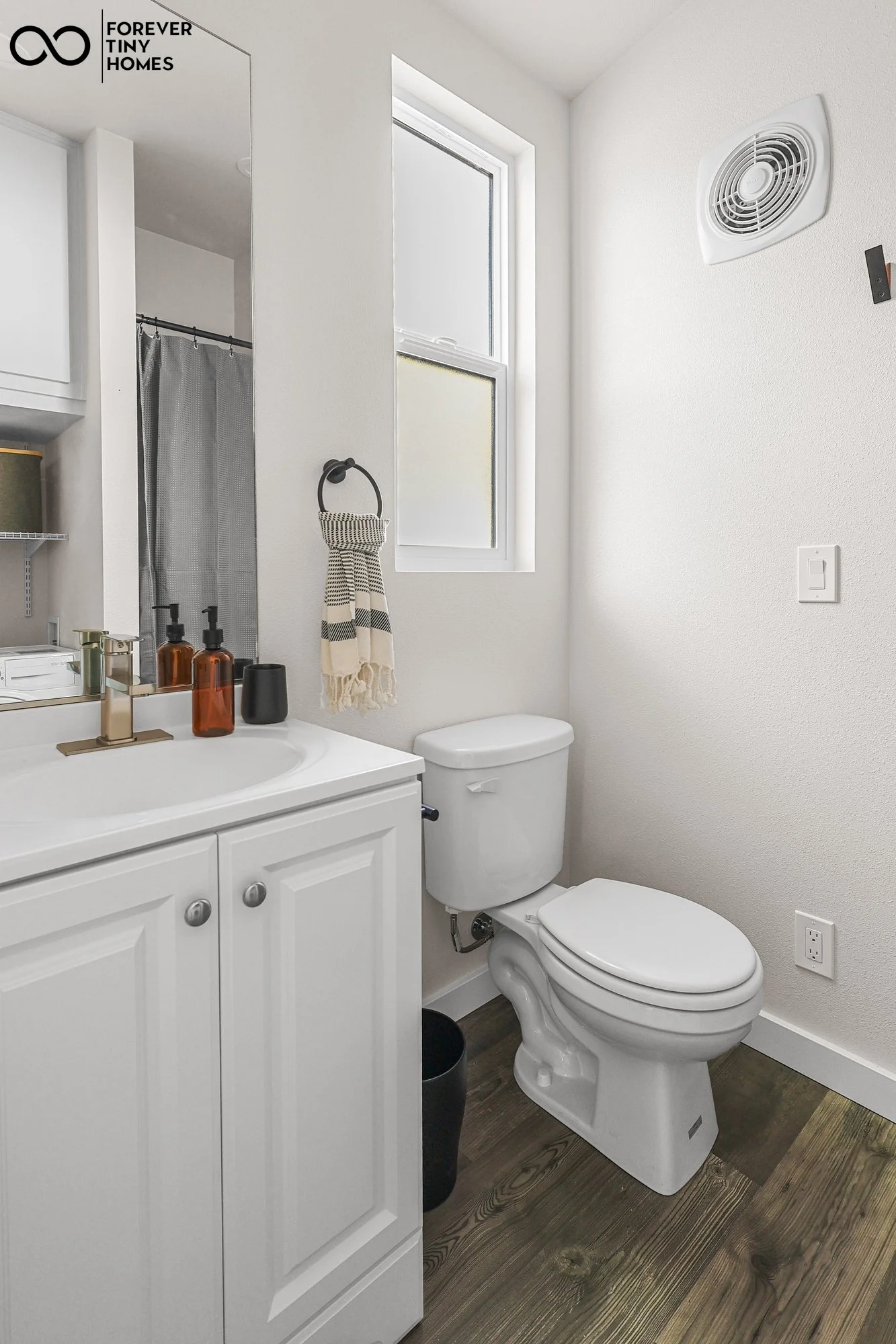 Forever 32′ bathroom featuring a vanity with cabinet storage, a flush toilet, and a window that brings natural light into the space.