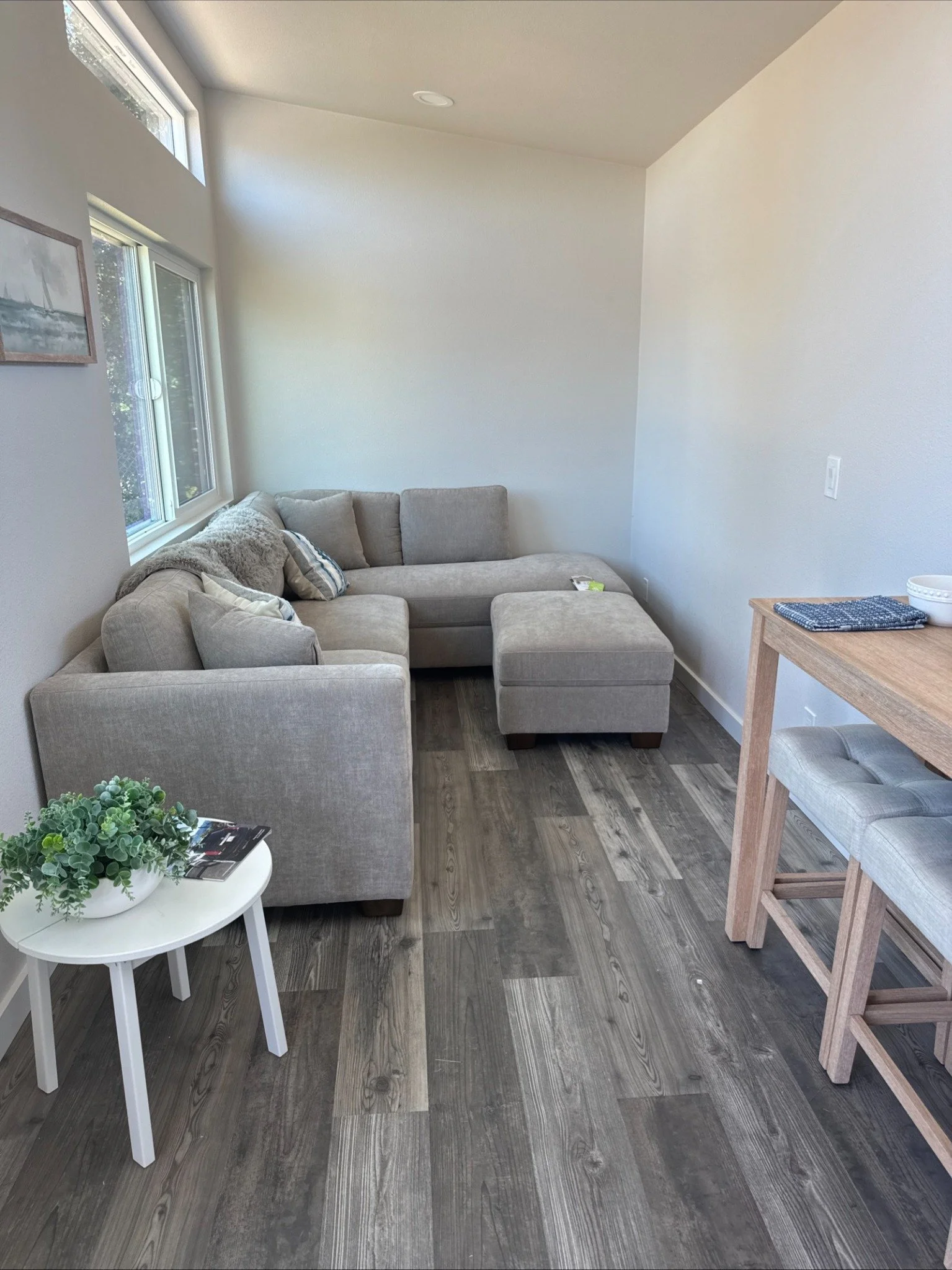 Forever 40′ 2B shown with an open living and dining area, featuring Pergo Outlast flooring, finished drywall walls, and large windows for natural light.