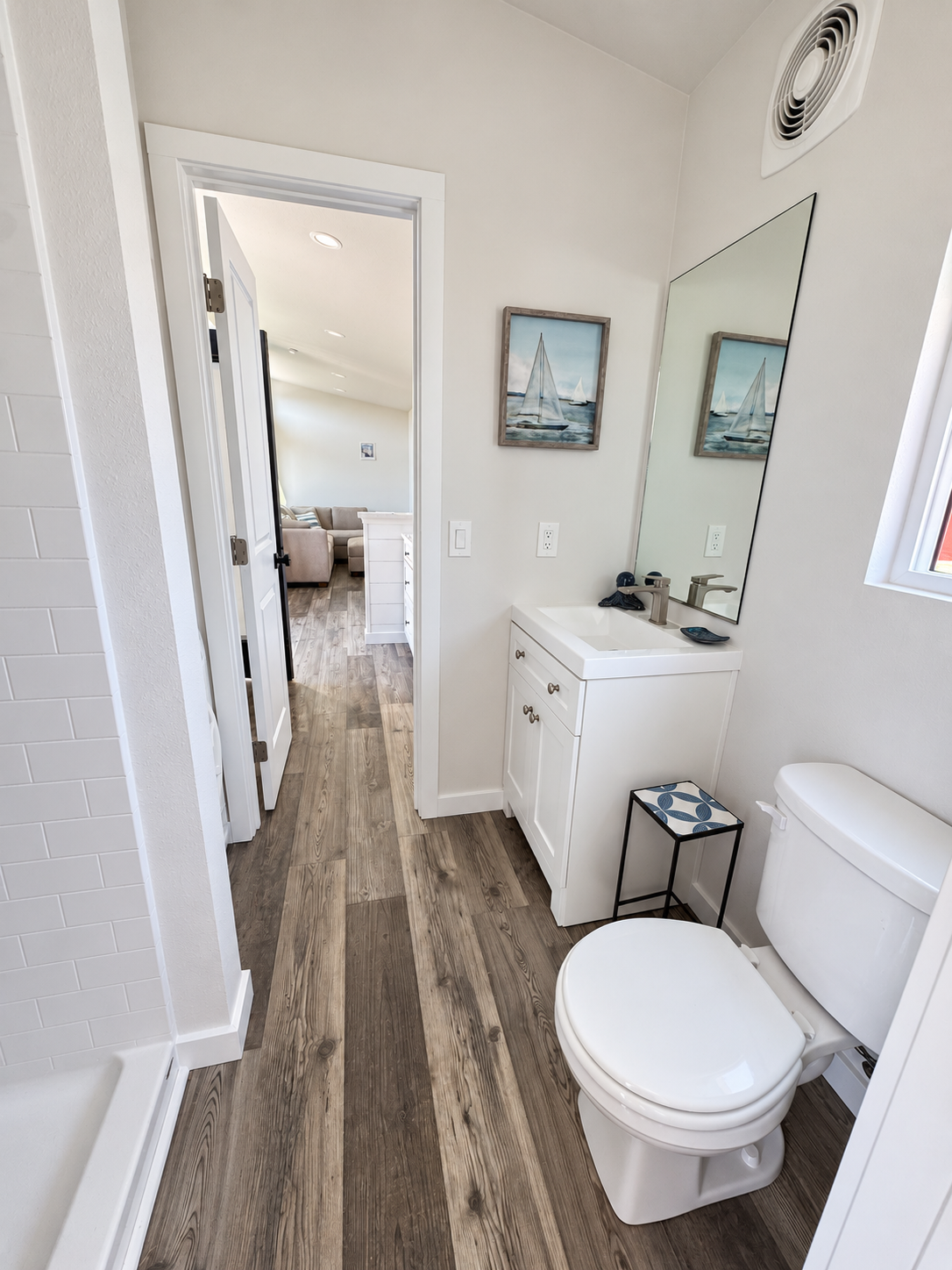 Forever 40-foot 2B bathroom with a white vanity, wall mirror, and doorway leading toward the bedroom.