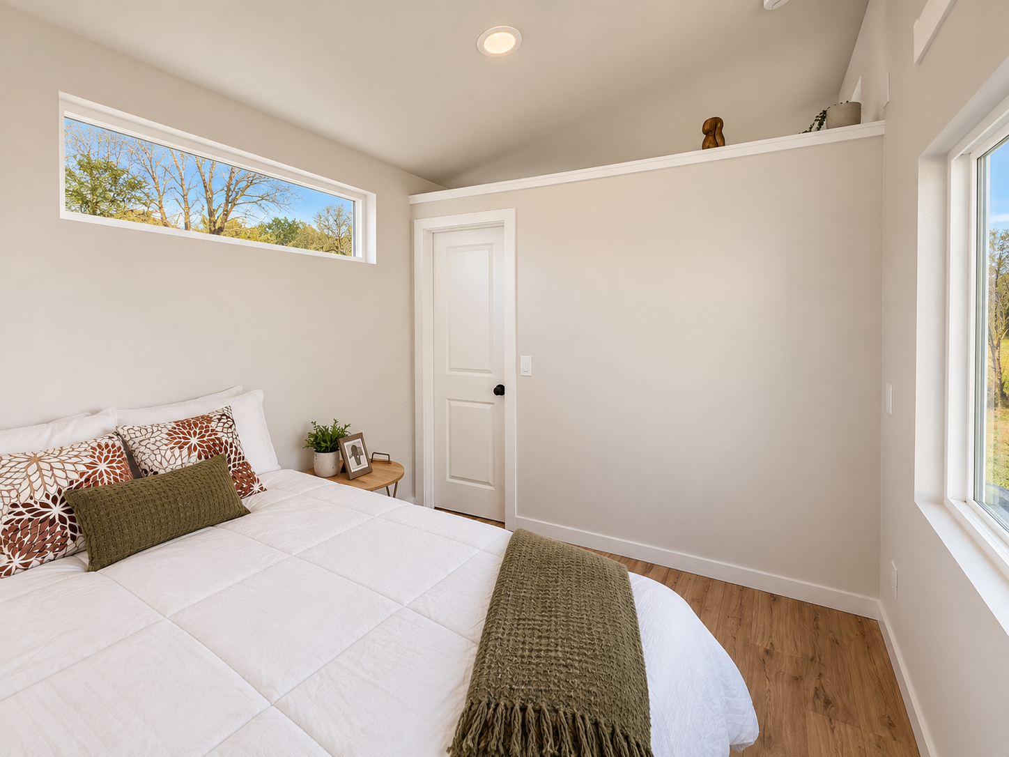 Forever 40′ 2B bedroom featuring Pergo Outlast flooring, finished drywall walls, and a separate bedroom door for privacy.