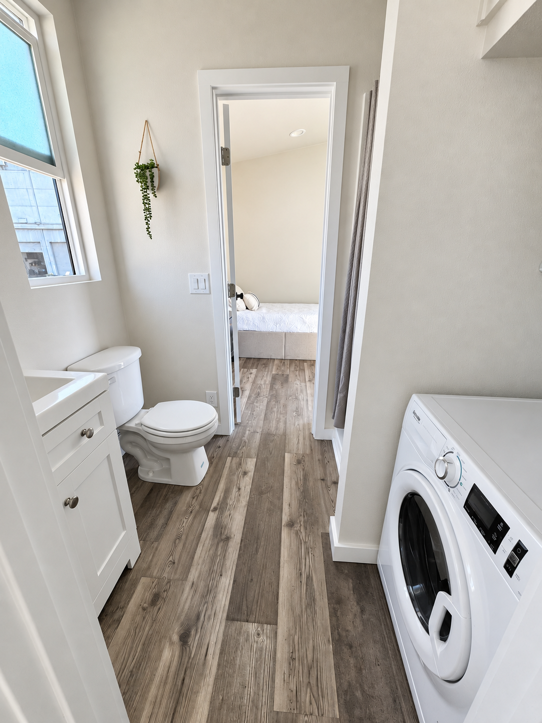 Forever 40′ 2B bathroom and laundry area featuring a combination washer and dryer, a window for natural light, and direct access to the private bedroom.