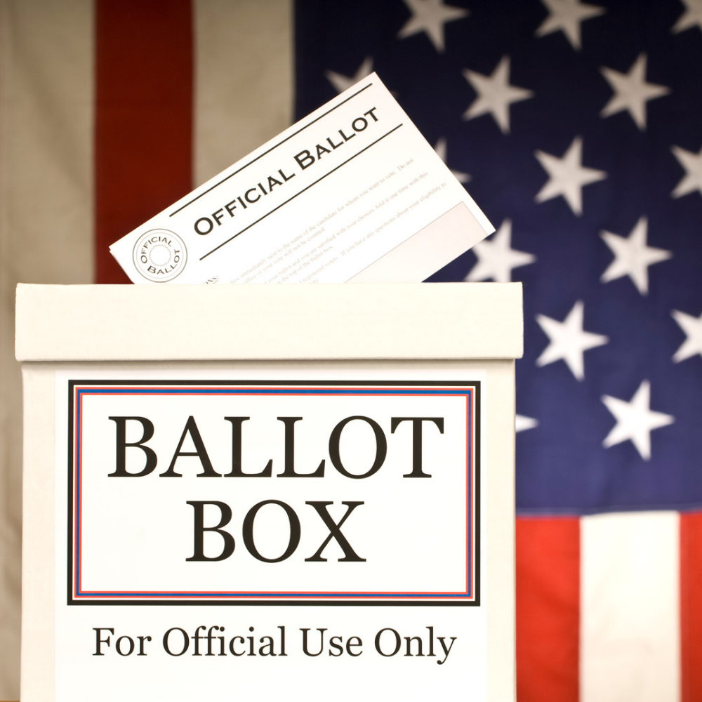 A ballot box with an official ballot being inserted, with a background featuring a US flag.