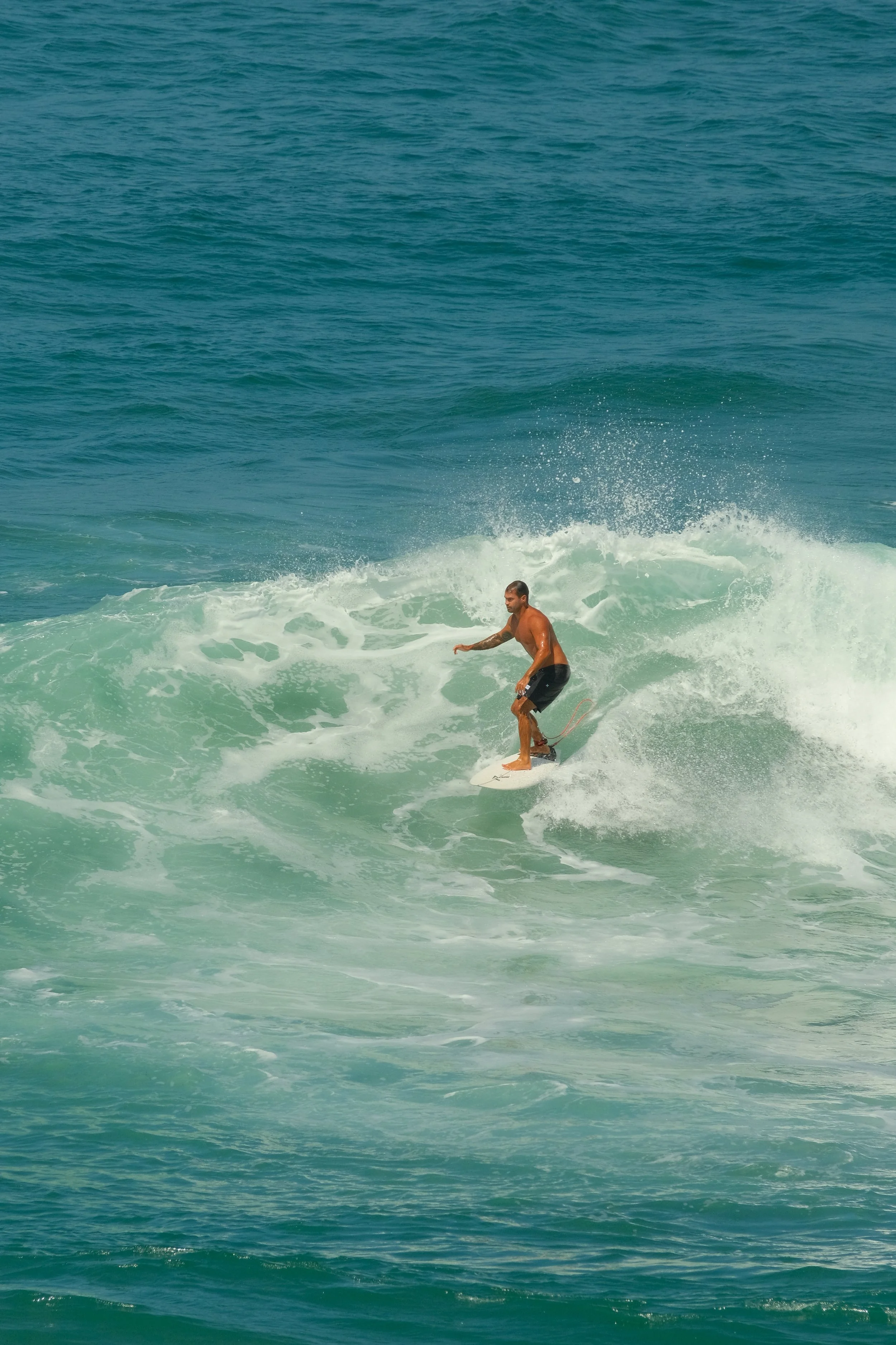 A man surfing on a wave in the ocean.