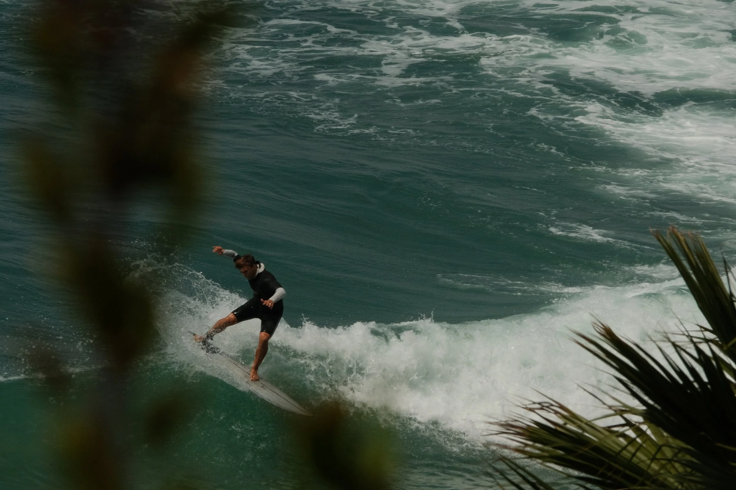 A person surfing on a large wave in the ocean.