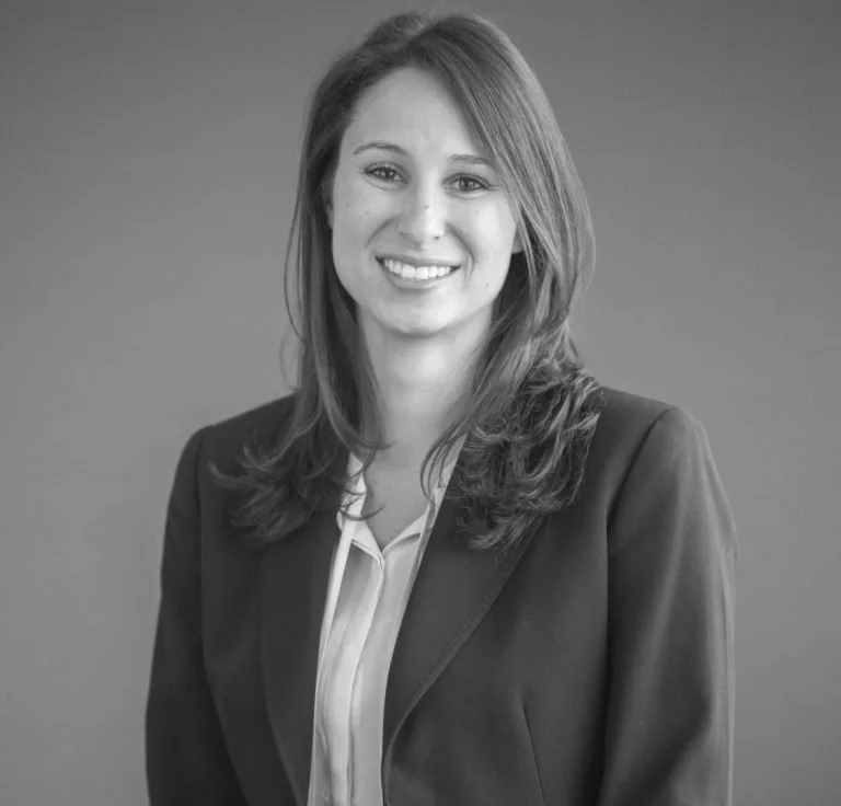 Smiling woman in business attire with long hair, monochrome photo.