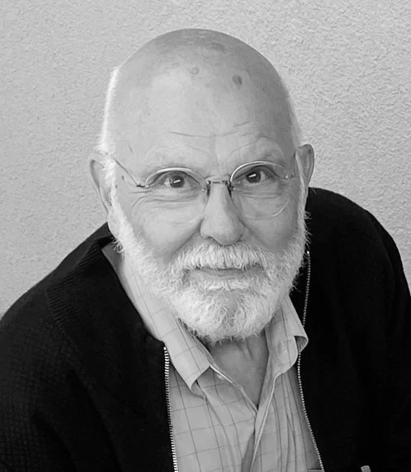 Elderly man with glasses and a beard in black and white photo.