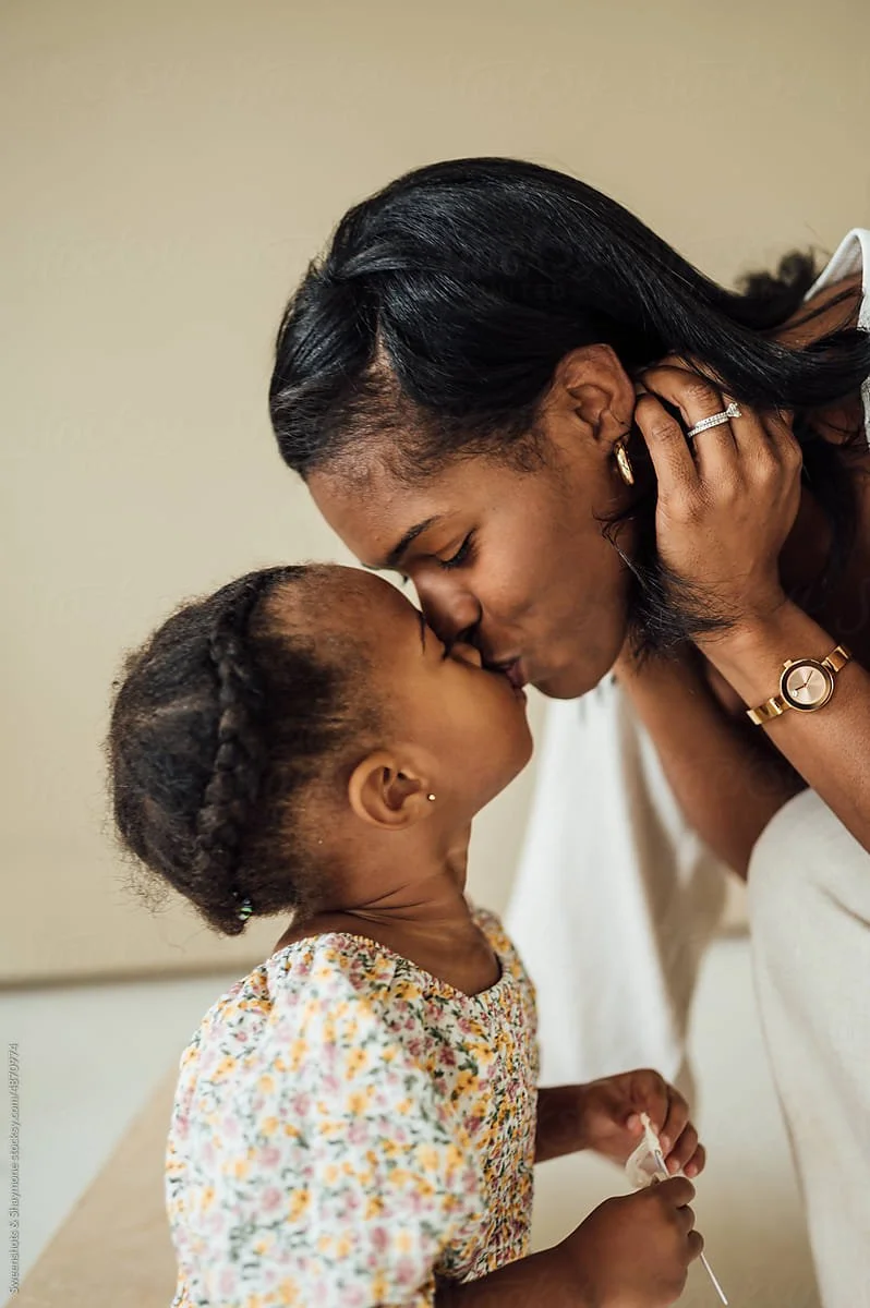A mom kissing her toddler