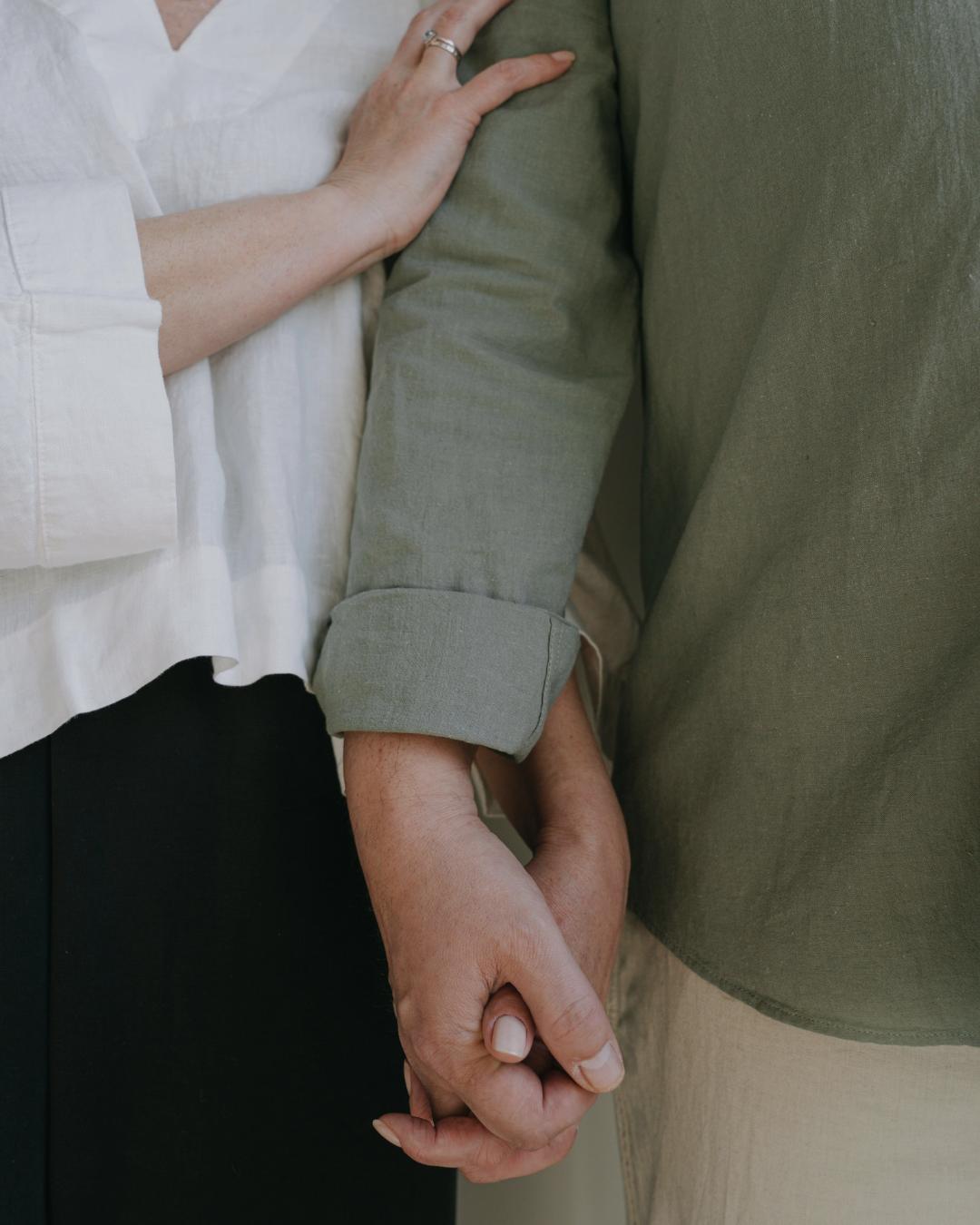 A mature couple holding hands together, representing support during long-term care planning