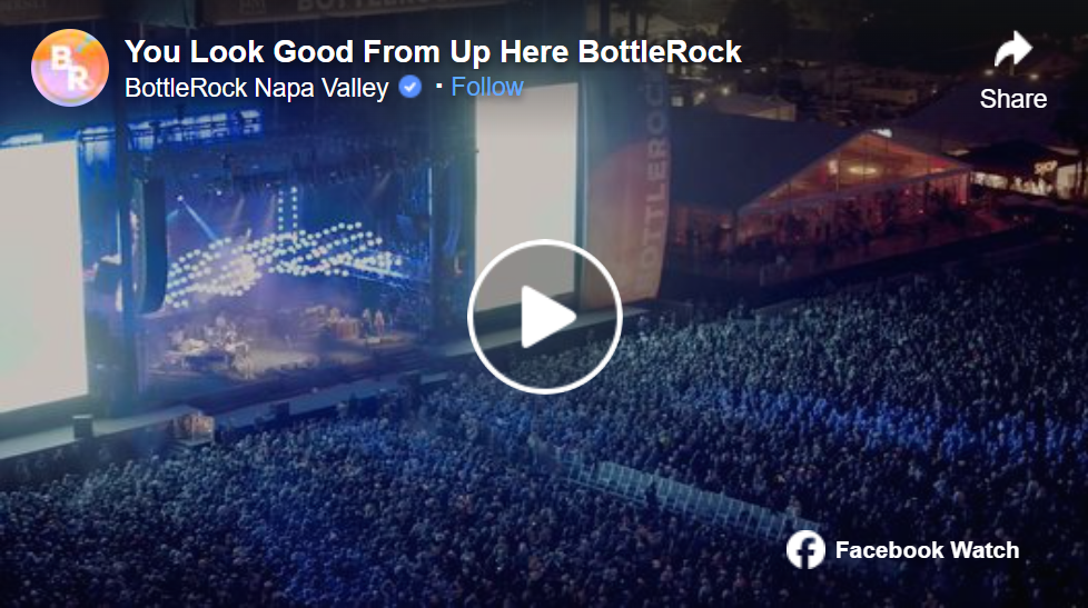Nighttime view of a large outdoor concert stage with bright lights, surrounded by a massive crowd at BottleRock Napa Valley.