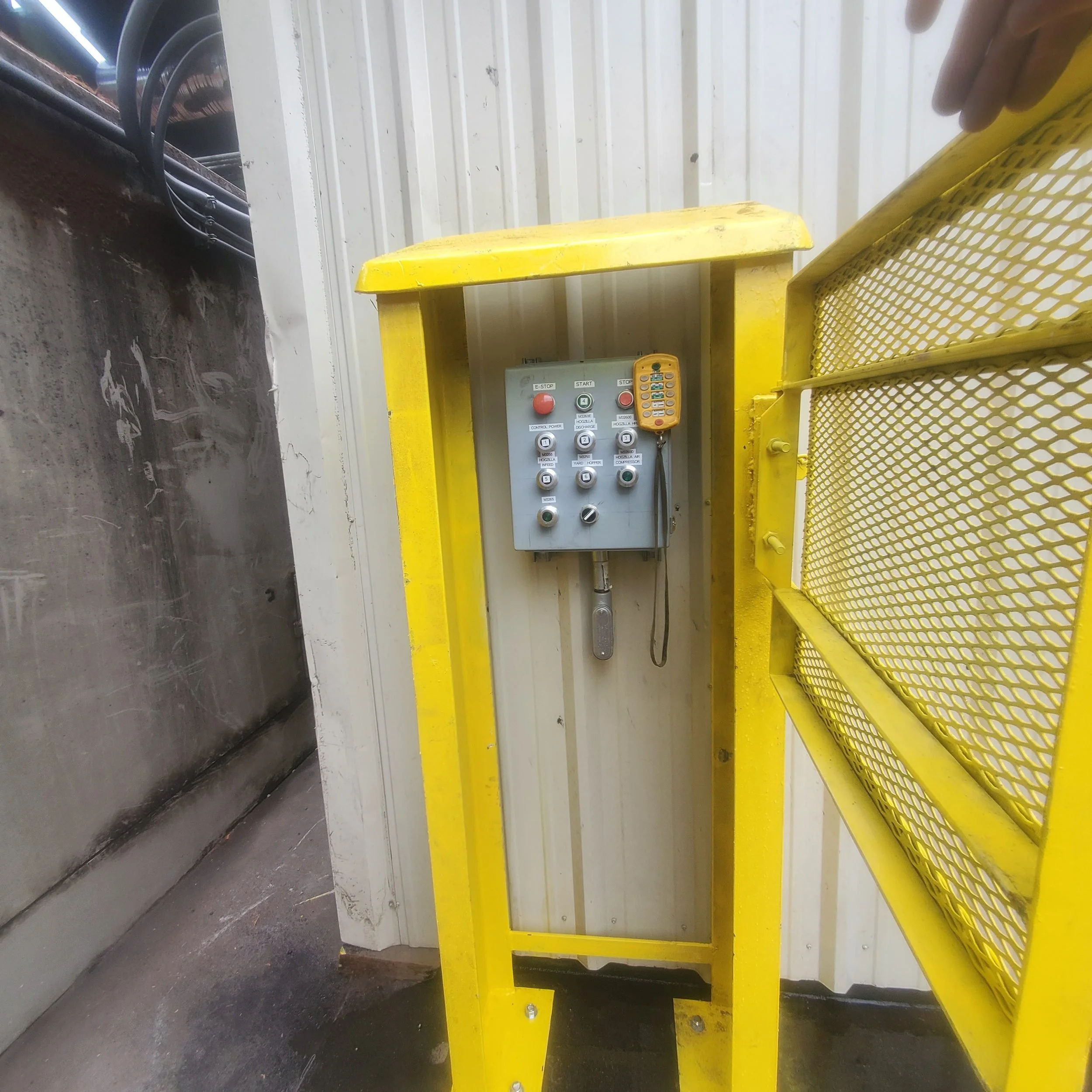 Custom heavy-gauge steel safety guard with an expanded-metal gate around an industrial control station