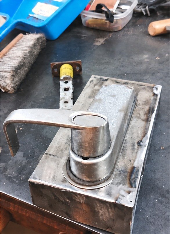 New steel replacement gate lock box fabricated in the shop, with the lever handle test-fitted