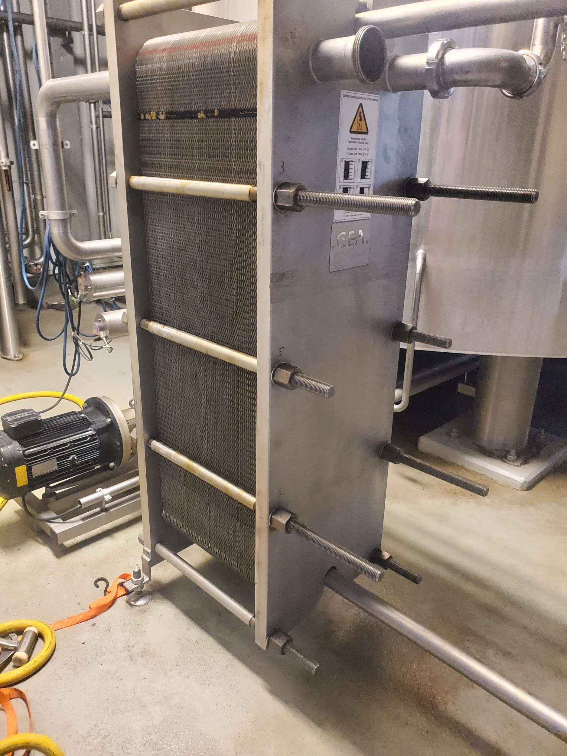 Stainless steel plate heat exchanger and piping in an industrial food processing facility