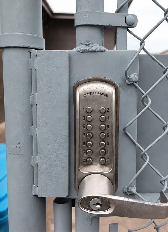 Replacement steel lock box installed on the gate and painted, with the original keypad lock refitted
