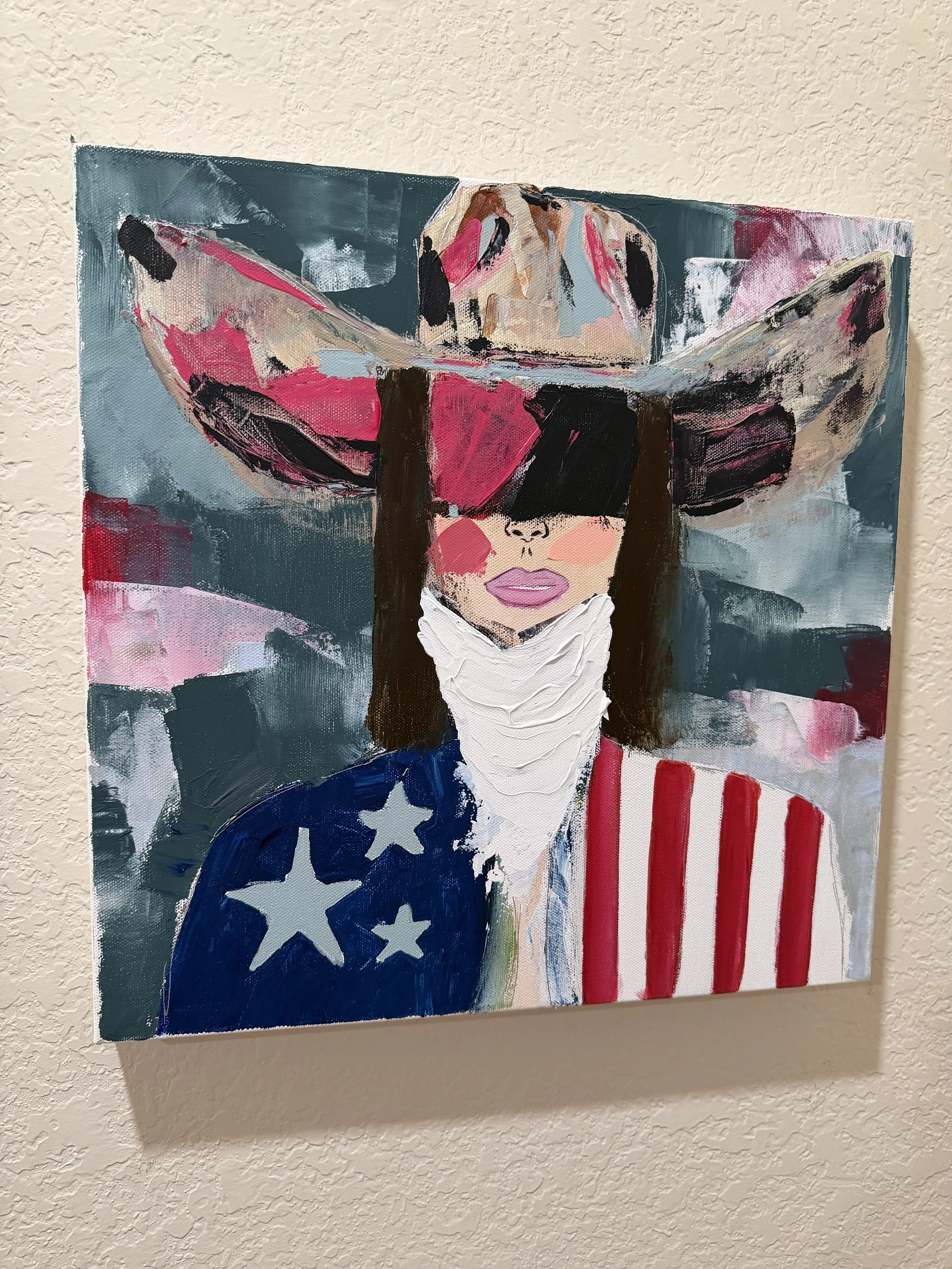 An abstract painting of a woman with dark hair, wearing a blindfold, with a patriotic theme including stars and stripes in red, white, and blue on her face and clothing, against a background of brushstrokes in various colors.