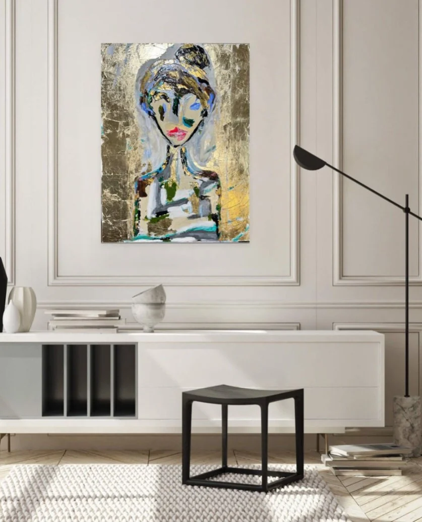 Modern living room with a large abstract portrait of a woman hanging on the wall above a white sideboard. The room has a black and white color scheme with a black side table, a white textured rug, and a black arc floor lamp. Decorative vases and book
