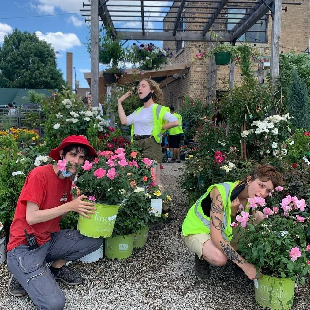 employees smiling holding plants at tallgrass garden formerly christy webber farm & garden