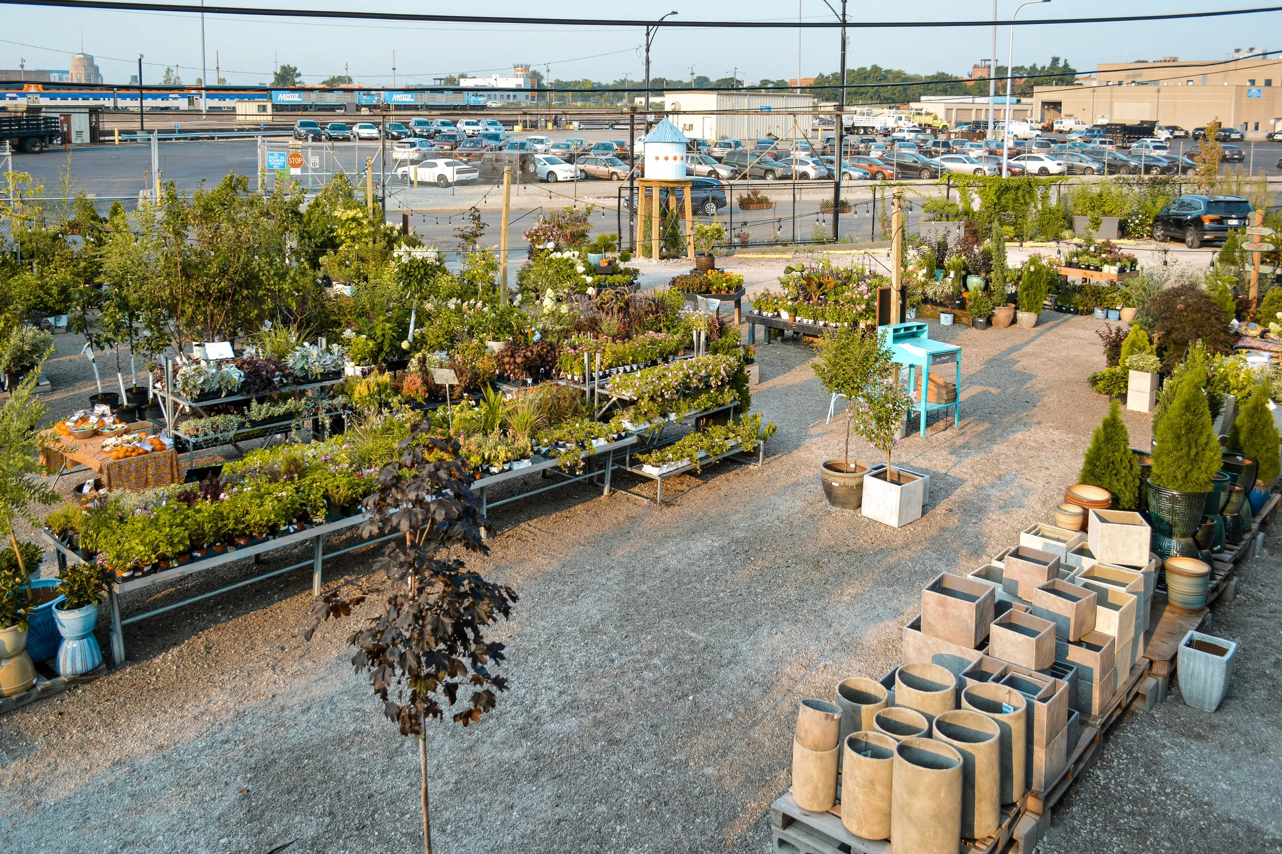 tallgrass garden formerly christy webber farm & garden with various potted plants, flowers, and shrubs for sale, organized on tables and shelves